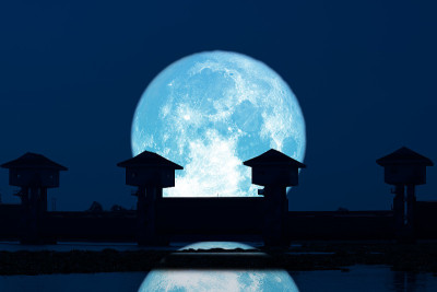 在黑暗的夜空中，超级蓝月亮和剪影大坝