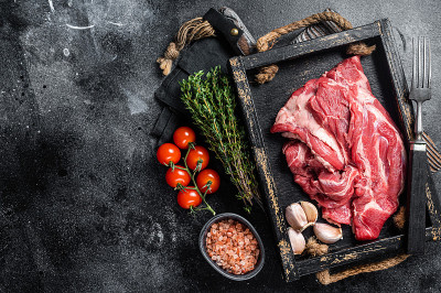 羔羊颈肉或羊肉颈肉，生的无骨肉在木制托盘。黑色背景。前视图。本空间