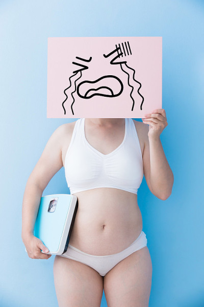 超重的女人拿着哭泣的广告牌