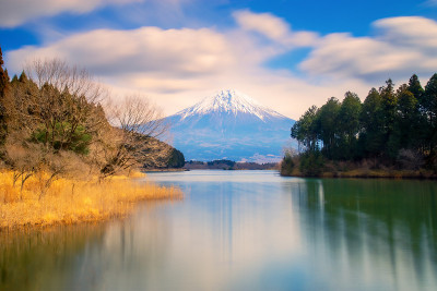 富士山在狸猫湖上的长曝光景观，前景是流动的云天和水面的倒影。