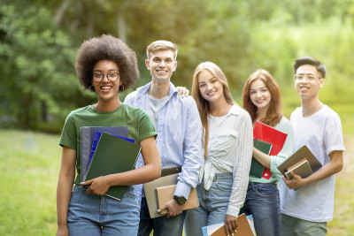 一群年轻快乐的多民族学生在大学校园外一起摆姿势