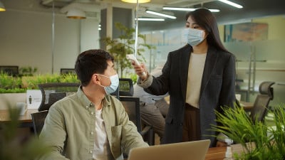 一位男士的同事正在测量体温