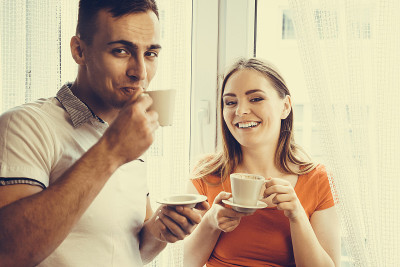 年轻夫妇在家里喝茶或喝咖啡
