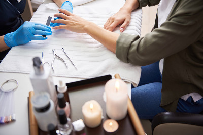 修甲师傅用金刚砂板锉削女士指甲