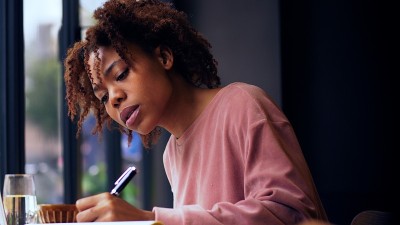 年轻漂亮的非洲女人在室内写作