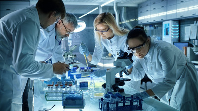 医学研究科学家团队共同致力于新一代实验性药物治疗。实验室看起来繁忙，明亮和现代。