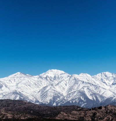 在一个阳光明媚的冬日，从阿根廷门多萨的波特雷里洛斯望去，雪山般的安第斯山脉。