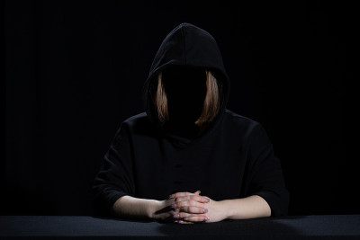 一个穿着黑衣的女人从黑暗中出现。