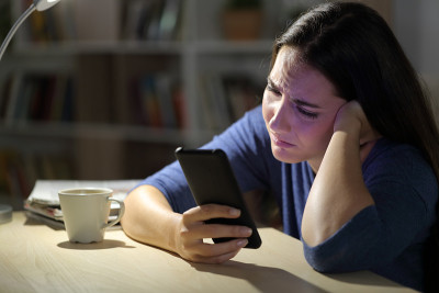可怜的女人抱怨晚上在家看手机