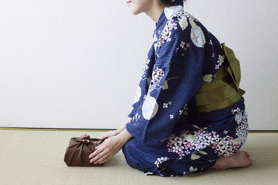 穿着日本服装的妇女手展示礼物