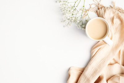 平铺格子图案和一杯咖啡在白色的桌子上。Hygge，秋天惬意的心情，舒适的概念。平躺，俯视图