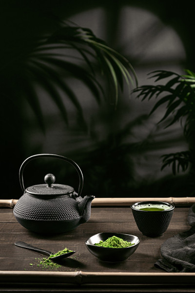 抹茶粉和茶配件在深色木质底座上。茶道。日本传统饮料。垂直格式。
