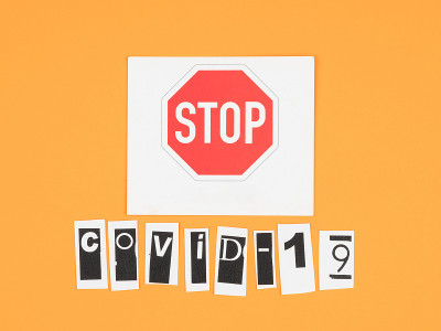 COVID-19和橙色背景的停止标志。