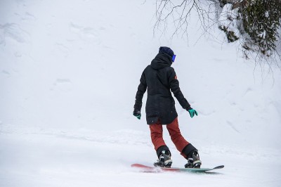 一个女孩骑着滑雪板从山的一侧滑下来
