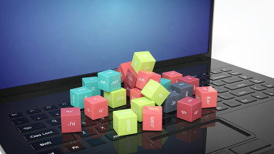 在黑色笔记本电脑的键盘上显示域名立方体的3D渲染