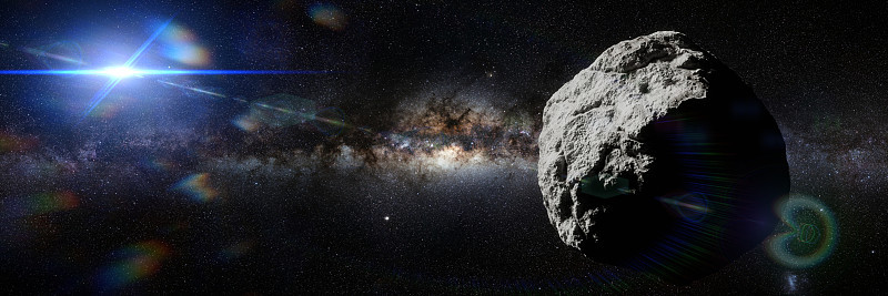 太空中的小行星被太阳照亮，旗帜格式的背景