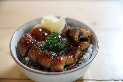 日本食物鳗鱼顿，烤鳗鱼在日本米饭上的木材背景