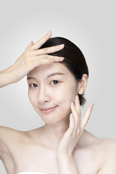亚洲年轻女子触摸脸与放松的表情