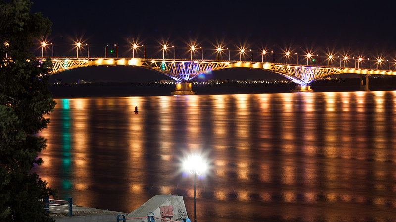 伏尔加河上的萨拉托夫桥夜景，长时间曝光后，许多灯光反射在水面上