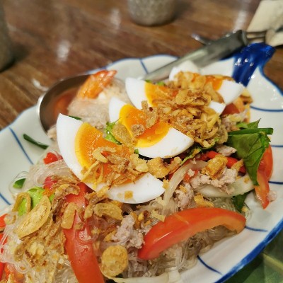 把鸡蛋放在咖喱蔬菜沙拉和虾上