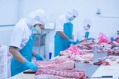 在工厂里切肉的工人