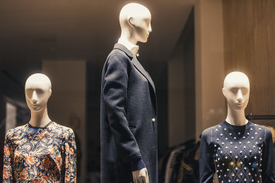 在米兰的一家商店里，妇女们穿着挂在衣架上的衣服