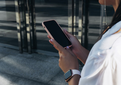 一位成功的商业女性使用iPhone 12 pro和咖啡杯
