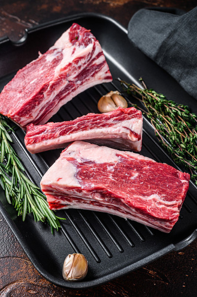 牛、小牛、小排骨、肉放在烤盘上准备烹调。黑暗的背景。俯视图