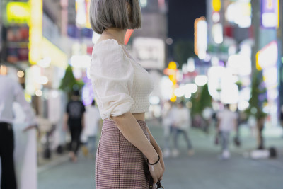 一名年轻女子晚上在东京摆造型