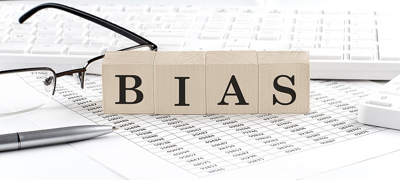BIAS用键盘、计算器、图表、眼镜写在木制的立方体上。经营理念