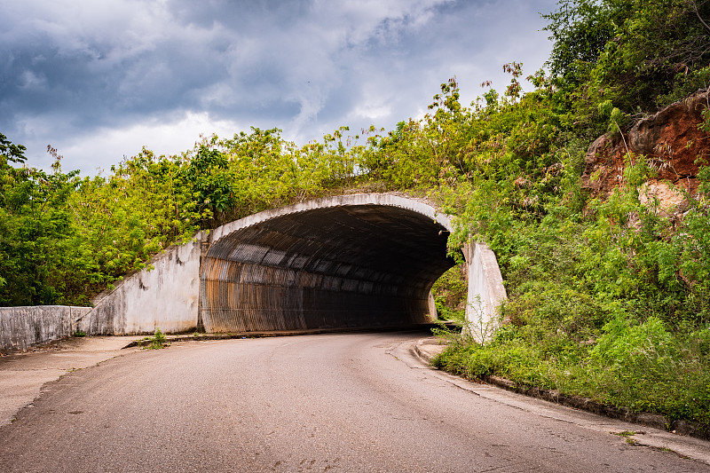 位于乡村道路/街道上的黑暗隧道的入口/入口/入口通道/出口。向地下通道开放