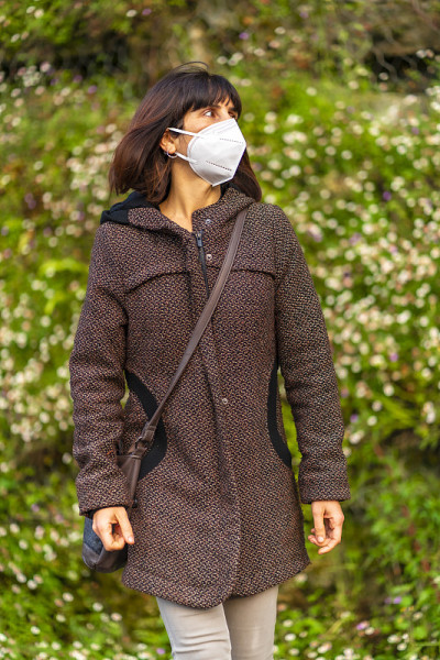 一个戴着白种人面具的黑发女孩在公园里的生活方式。首次接触未受控制的Covid-19大流行