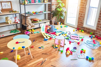 美丽的幼童坐在地板上玩积木玩具在幼儿园