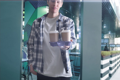 拿着装着几个咖啡纸杯的托盘的人