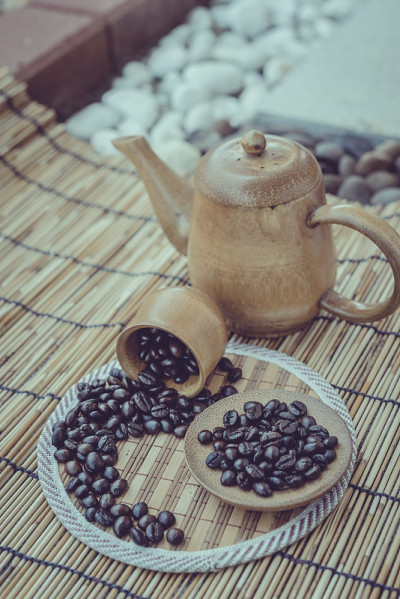竹木背景上的咖啡豆和杯子。