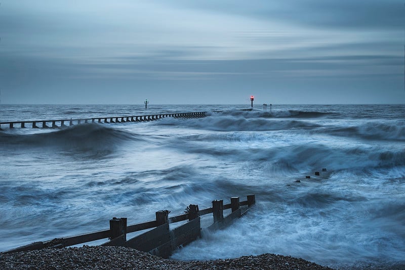 美丽而戏剧性的暴风雨景观，日出时海浪撞击海滩的景象