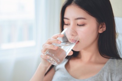 亚洲妇女生病吃药喝水。