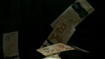 落在空中的加拿大元钞票上的黑色背景。高质量的跌落美元钞票