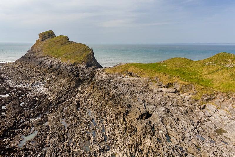 退潮时壮观的岩石海岸鸟瞰图(威尔士Worm's Head)