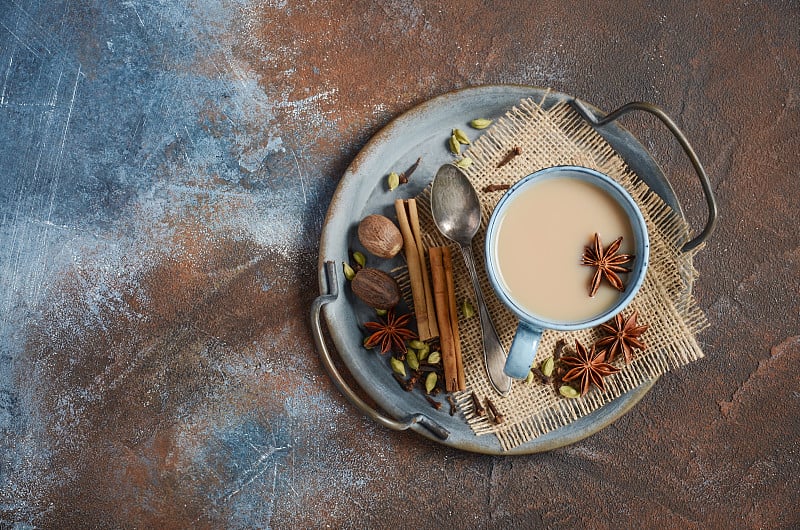 印度玛沙拉茶。五香茶与牛奶在黑暗生锈的背景。