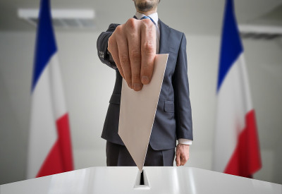 在法国大选。选民在投票球上方手持信封。广角镜头。