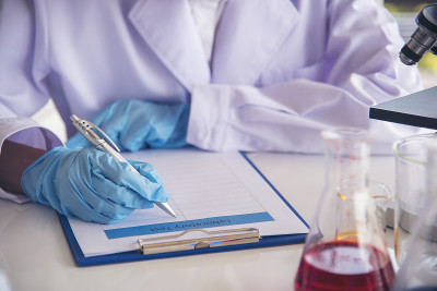 特写女科学家手用滴管在实验室看科学显微镜医学试验，研究生物化学。女性技术员实验室分析血液科学药物研究