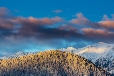 冬天的风景在山上，有白雪覆盖的山峰和落日的月亮
