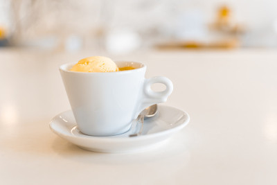 白色木桌上放着陶瓷杯装的Affogato咖啡和冰淇淋