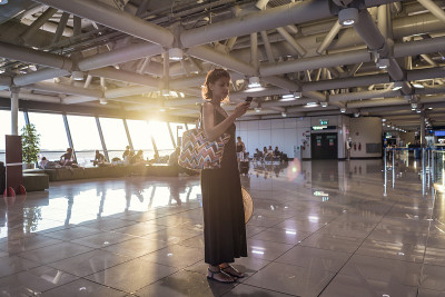 机场上的年轻美女。一个正在等飞机的女人正在用手机