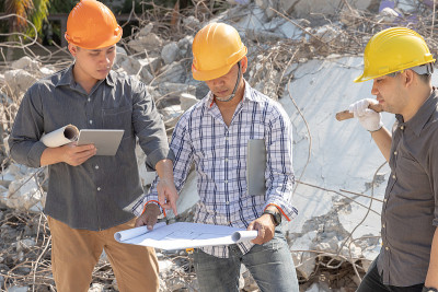 工程师建筑师和工人操作控制拆除旧建筑。