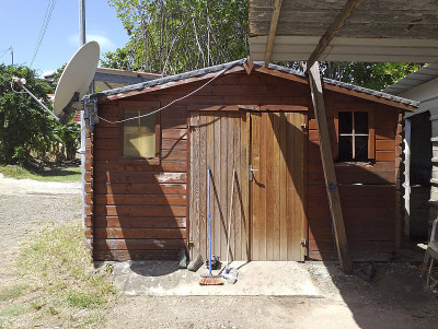 带有卫星天线的破旧木板的加勒比小屋。热带文化和技术。小屋syle背景。建筑和施工模式。