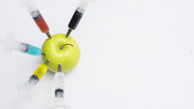 杀虫剂、硝酸盐、转基因和其他化学物质被用注射器注射到一个青苹果中。