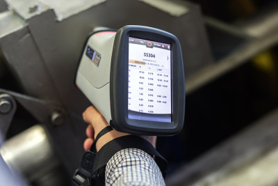 检验员是材料分析(pmi和xrf)是测量不锈钢(ASTM A 304-SS304材料)与数字便携式材