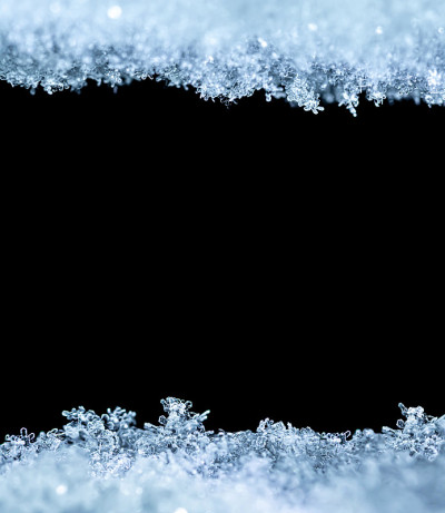 雪花特写的自然雪纹理，孤立在黑色背景上，中间有文本空间。节日礼品卡模板。雪的宏观纹理。